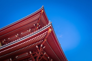 Japan. Tokyo. Roof of the temple of Asakus on the background of blue sky. Exterior of a japanese building. Temple of the Three Deities. Sensoji Church. Exterior of the temple roof with a swastika