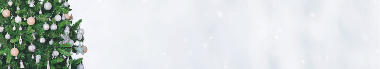 Holidays banner with decorated Christmas tree branches on snowy background. New Year template with copy space. 