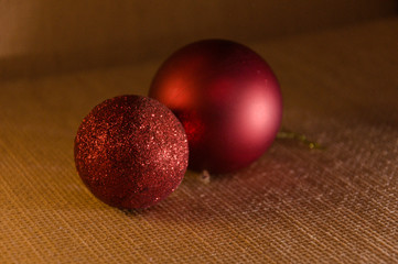 Two brighly red Christmas balls with glitter