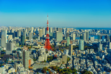 Japan. Tokyo. TV tower in Japan. Panorama of Tokyo view from a quadcopter. Red and white television tower rises above the city. Tokyo on the background of blue sky. Television tower in a Japanese city