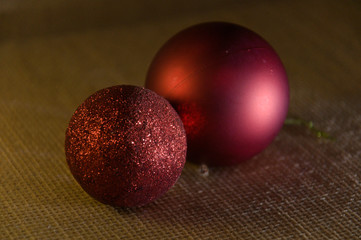 Two brighly red Christmas balls with glitter