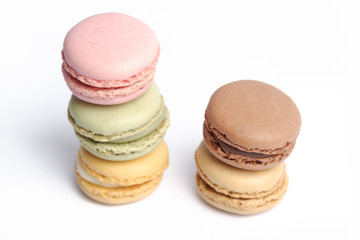 macaroons in several colors and tastes stacked on a white background