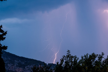 lightning in the evening on the background of the earth's surface and bushes on the side