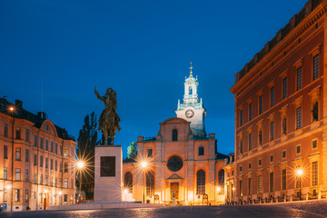 Fototapeta na wymiar Stockholm, Sweden. Statue Of Swedish King Karl XIV Johan Sitting On A Horse Near Great Church Or Church Of St. Nicholas And Royal Palace. Famous Popular Destination Scenic Place In Night Lights