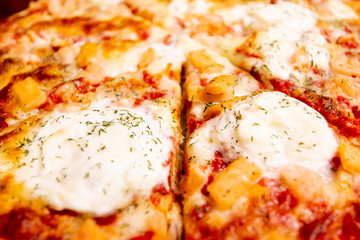 Italian pizza slices focus close up with tomato, mozzarella and meat