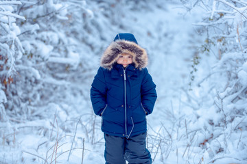 Fototapeta na wymiar Winter kids clothes. Winter portrait of happy cute child. The morning before Christmas. Winter at countryside. Boy dreams of winter time.