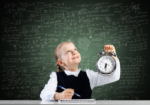 Smiling little girl holding alarm clock