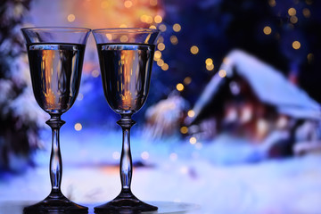 Two glasses with champagne sparkling wine on a winter evening background. The atmosphere of...