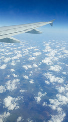 Fototapeta premium Wing of an airplane flying above the clouds