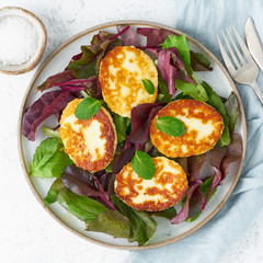 Cyprus fried halloumi with salad mix, beet tops. Lchf, pegan, fodmap, paleo, scd, keto, ketogenic diet. Balanced food, clean eating recipe. Top view, white background