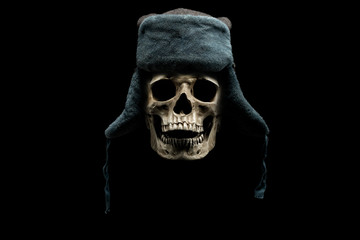 Human skull in winter hat isolated on black background.  Hat with ear flaps. Cold weather concept.