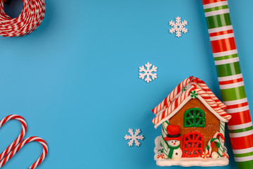 Christmas blue background. Toy house. Christmas snowflakes made of wood. Colored paper for wrapping gifts.
