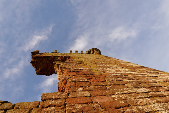 Looking directly up the thick sandstone walls of the Keep of the ruined Red Castle at Lunan, with some of the top structure overhanging