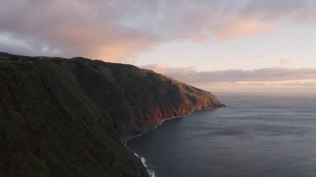 Aerial view of dramatic coastline during sunset. Beautiful cinematic scene. Flying high above the ocean.