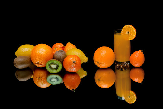 ripe fruits and drink on a black background