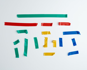 Fototapeta premium set of torn multicolored rubber pieces of electrical tape glued to a white background