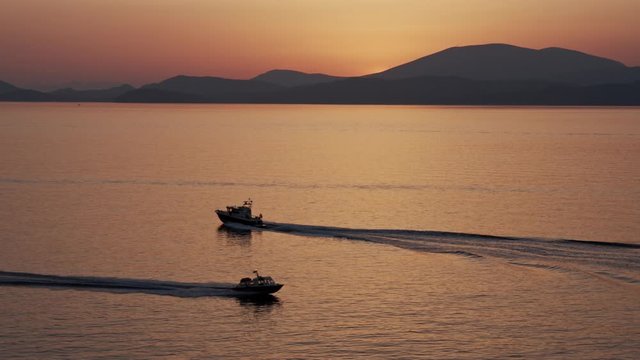 Barcos Cruzando el horizonte en la puesta del sol en la isla hydra