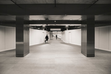 Black and white under ground tunnel walkway with people