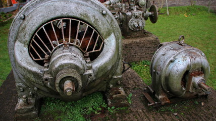 A statue of a tea leaf processing machine monument in a park on a mountain