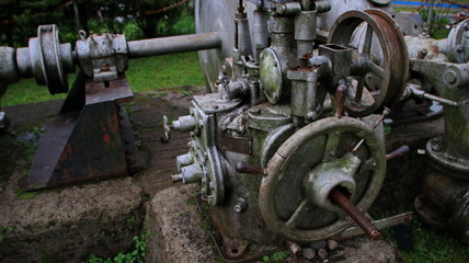 A statue of a tea leaf processing machine monument in a park on a mountain