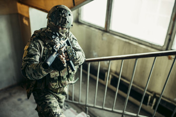 brave and strong soldier in military uniform holding rifle in hands. military service concept