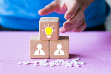 Leader with idea and innovation, Woman hand flips cube with icon light bulb and human symbol in healthcare.