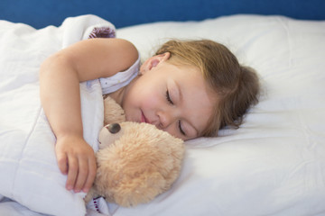 Obraz na płótnie Canvas Caucasian child of three age sleeping in the bed with bear toy during day