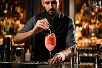 Bartender putting grapefruit slice in a drink