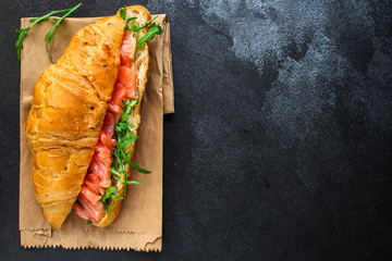 fish sandwich and greens, Smorrebrod (salted salmon, croissant, bread, arugula and other ingredients) menu concept. food background. top view. copy space