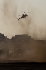 Military combat and war with helicopter flying into the chaos and destruction. Military concept of...