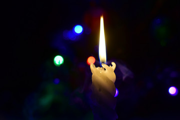 Christmas candles on a black background with lights