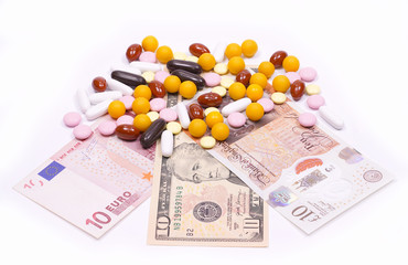 Different types of pills are located in dollars, euros and pounds sterling.Vitamins, tablets and dieta supplements of different colors. The production and sale of drug large amounts of mone
