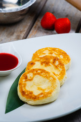 Traditional breakfast with coffee and cheesecakes, cottage cheese pancakes on a plate with syrup and jam.