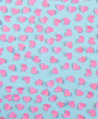 Pink paper hearts on a blue background. Valentine's day. Symbol of love. Copy space.