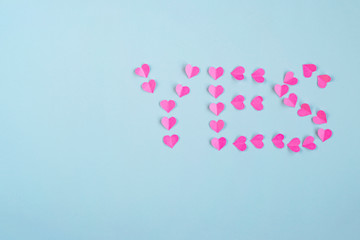 Engagement-proposal.  Pink paper hearts on a blue background. The concept of Valentine's day. Symbol of love. Copy space.