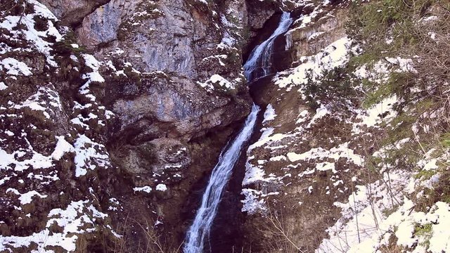 Wasserfall in einer tief eingeschnittenen Schlucht mit Schnee auf den Felsen