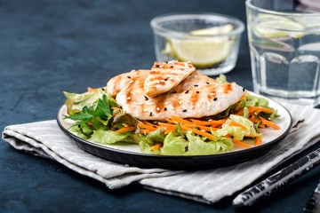 The concept of healthy diet. White grilled chicken meat with lettuce leaves on a plate