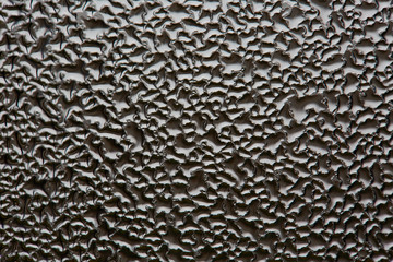 monochrome abstraction blurry drops of water on the glass. dark background for design.