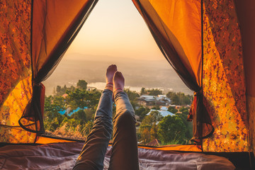 Low Section Of Woman Relaxing In Tent Against Sky During Sunset - Powered by Adobe