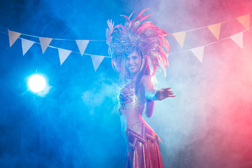 Cabaret, dancer and holidays concept - Cute young girl in bright colorful carnival costume on dark background