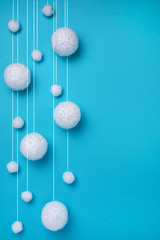 Christmas composition. The concept of a winter festive background, snowfall from white balls on a blue background. Christmas, winter, new year concept. Minimalism flat lay