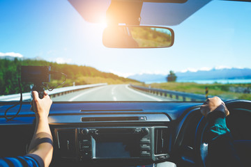 Travelers  driving and using camera to recording video vlog, stunning landscapes view on a country road trip. Travel blogger and vlogger concepts. Happy and safe journey with rental car insurance.