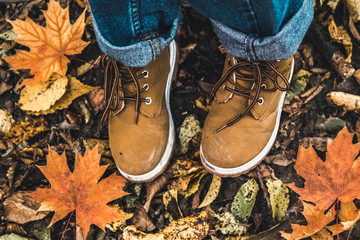 Boots against the background of dry leaves in the forest