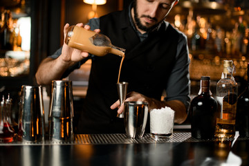 Bartender pouring a liquor straight to jigger