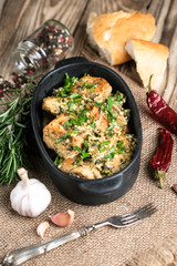 Baked chicken in garlic sauce with cilantro, herbs and spices on a rustic background. Chkmeruli is a traditional dish of Caucasian Georgian cuisine.