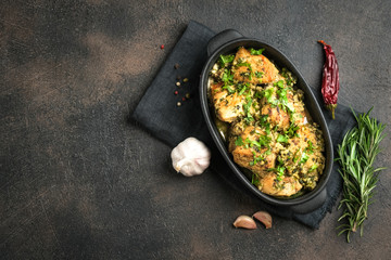 Baked chicken in garlic sauce with cilantro, herbs and spices on a dark background. Chkmeruli is a traditional dish of Caucasian Georgian cuisine.