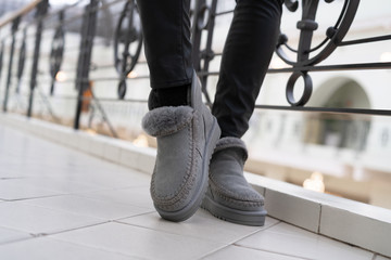 gray female stylish low uggs with fashionable stitching on legs indoors