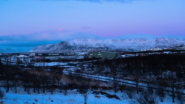 The Busy City Roads Of Esjan, Iceland During Sunset With Snowy White Mountains In The Background - Time Lapse