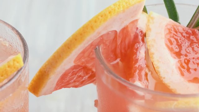 Grapefruit and rosemary gin cocktail in a transparent glass. Refreshing drink with ice. lemonade with grapefruit and rosemary. Concept summer refreshing drink and ingredients