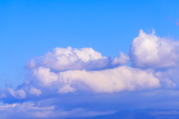 Fototapeta premium Dramatic puffy fluffy clouds isolated against blue skies